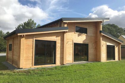 Maison en bois en kit en cours de montage sur sa dalle