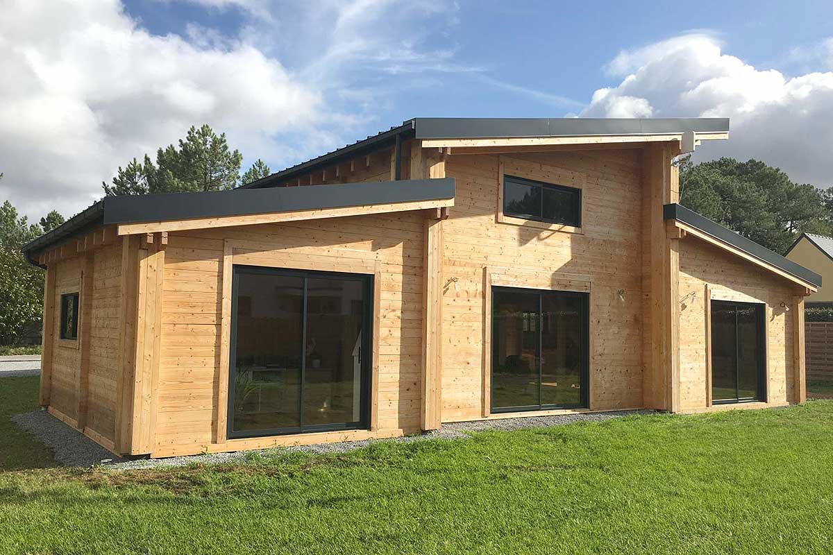Maison en bois en kit en cours de montage sur sa dalle